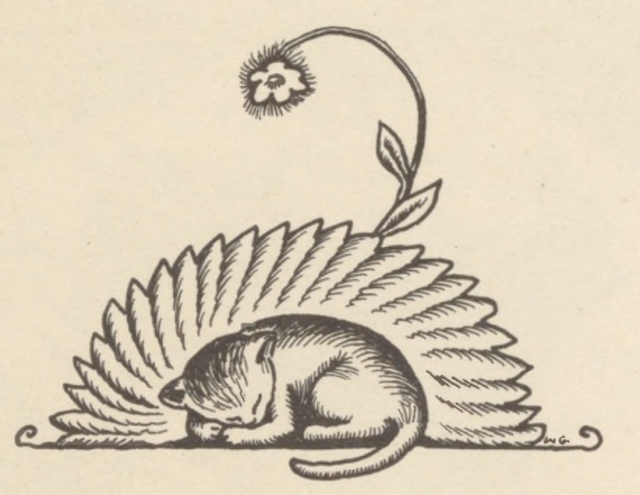 A kitten sleeps curled up on a cushion beneath an arching flower stem.